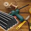 A collection of crafting and repair tools, including glue sticks, a glue gun, a knife, and tape, arranged on a wooden surface. Voir les images du produit