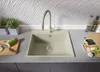 A kitchen sink area with a beige granite sink, a modern faucet, and various kitchen items like vegetables, bottles of oil, and plants. Produktbild-Vorschau