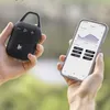 Hands holding a portable Bluetooth speaker and a smartphone outdoors. Voir les images du produit