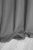 A close-up view of a gray curtain draped over a wooden floor. Produktbild-Vorschau