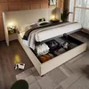 A bedroom scene featuring a large bed with storage, bedside tables with lamps, and a window. Náhled obrázku produktu