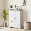 A white storage cabinet with a dark gray top, featuring three drawers on the left and a cabinet door on the right, is placed in a room with a plant and a basket. Anteprima dell’immagine prodotto