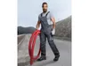 A man in work overalls stands outdoors holding a red hose. Náhled obrázku produktu