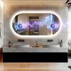 A modern bathroom vanity with two sinks and a large, illuminated oval mirror displaying a music visualization. Podgląd zdjęcia produktu