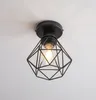 A black geometric ceiling light fixture with a visible light bulb against a white background. Produktbild-Vorschau