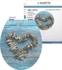 A toilet seat with a heart design made of driftwood on a blue wooden background, next to product packaging. Náhled obrázku produktu