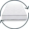 A white mattress with a diamond-stitched pattern and a dark blue trim, shown from a slightly elevated front-side angle. A circular arrow graphic surrounds the mattress, indicating rotation or flipping. Produktbild-Vorschau