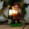 A garden gnome holding a lantern, standing on a grassy base with a mushroom. Produktbild-Vorschau