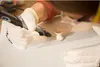 A person wearing gloves is using a Dremel tool on a small object. Anteprima dell’immagine prodotto