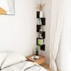 A corner shelf unit with decorative items and books next to a bed. Náhľad obrázku produktu