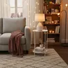 A cozy living room scene with a sofa, side table, and bookshelf decorated with string lights. Produktbild-Vorschau