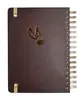 A dark brown spiral-bound notebook with a gold embossed snitch emblem and gold corner protectors. Produktbild-Vorschau