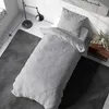 A neatly made bed with grey bedding in a well-lit room. Produktbild-Vorschau