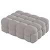 A gray upholstered ottoman or daybed is shown from a side-angle against a white background. Podgląd zdjęcia produktu
