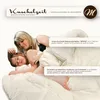 A woman and a child are lying in bed, covered by a duvet. Produktbild-Vorschau
