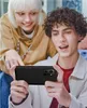 Two young people are looking at a smartphone held by the person in the foreground. Produktbild-Vorschau