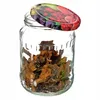 A glass jar filled with dried mushrooms, with a decorative lid placed nearby. Náhled obrázku produktu