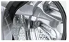 Close-up interior view of a washing machine drum, showing the stainless steel material and perforations. Produktbild-Vorschau