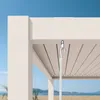 Close-up of a white pergola roof with a hook and hanging element, with a beach and ocean in the background. Náhled obrázku produktu