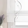 A close-up view of a white sheer Roman blind with a gray embroidered wavy line and bead pattern, partially covering a window. A vase of lavender is visible to the left. Produktbild-Vorschau