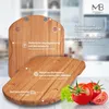 A wooden cutting board with tomatoes and lettuce on a table. Produktbild-Vorschau