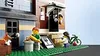 A Lego scene depicting a street with buildings, figures, a dog, and a bicycle. Náhled obrázku produktu