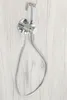 A chrome bidet sprayer and hose mounted on a light wood-grain textured wall. Podgląd zdjęcia produktu