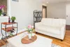 A living room scene with a white sofa, coffee table, and a wine rack. Podgląd zdjęcia produktu