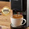 Close-up of a coffee machine brewing espresso into a white cup, with a gold badge indicating "19BAR Espresso". Produktbild-Vorschau