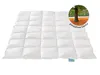 A white quilted comforter is laid out flat on a white background. A circular inset image shows a tree in an autumn landscape. Náhled obrázku produktu