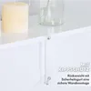 Close-up of a white shelf with a candle and a glass vase, showing a safety strap attached to the shelf and wall. Produktbild-Vorschau