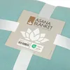 A close-up of a teal blanket with a product tag attached. Produktbild-Vorschau