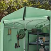 Inside view of a green outdoor storage shed, showing various items stored on shelves and hung on the wall. Produktbild-Vorschau