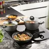 A collection of cookware is arranged on a modern induction stovetop, with some food being cooked in the pots and pans. Produktbild-Vorschau