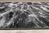 A close-up view of a rug with a marble-like pattern. Voir les images du produit