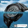 A digital watch partially submerged in water, with a blue sky and clouds in the background. Náhled obrázku produktu