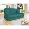 A teal sofa is shown in a well-lit living room with a bookshelf and dining area in the background. Náhled obrázku produktu