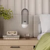 A bedside table with a pendant light, books, a decorative object, and a glass of water. Podgląd zdjęcia produktu