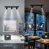 A split image showing a modern office/workspace on the left and a cafe interior on the right, both illuminated by track lighting. Produktbild-Vorschau