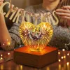 A person is decorating for Christmas with a heart-shaped lamp. Produktbild-Vorschau