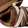 A close-up view of the inside of a brown UGG sneaker, showing the laces and the UGG logo. Produktbild-Vorschau