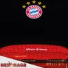 A nighttime shot of the Allianz Arena with the FC Bayern München logo above it. Produktbild-Vorschau