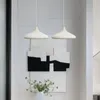 Two pendant lights hang above a vase of flowers and abstract art. Produktbild-Vorschau