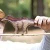 A person is holding a toy dinosaur on a rope outdoors. Podgląd zdjęcia produktu