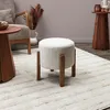 A living room scene with a stool, chair, and side table. Voir les images du produit