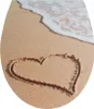 A heart drawn in the sand on a beach with a wave washing ashore. Produktbild-Vorschau
