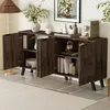 A dark wood sideboard with open doors, displaying books, a vase, and decorative items, set in a room with a floor lamp and artwork. Produktbild-Vorschau