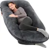 A pregnant woman is sleeping comfortably on a large, U-shaped pillow. Náhled obrázku produktu