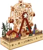 A wooden Ferris wheel decoration with small figures and a house, set against a white background. Náhled obrázku produktu