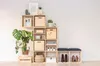 A modular cube shelving unit with various items displayed on and in it, including plants, books, decorative items, and shoes. Produktbild-Vorschau